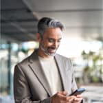 Man reads about using AI in the boardroom on his phone.