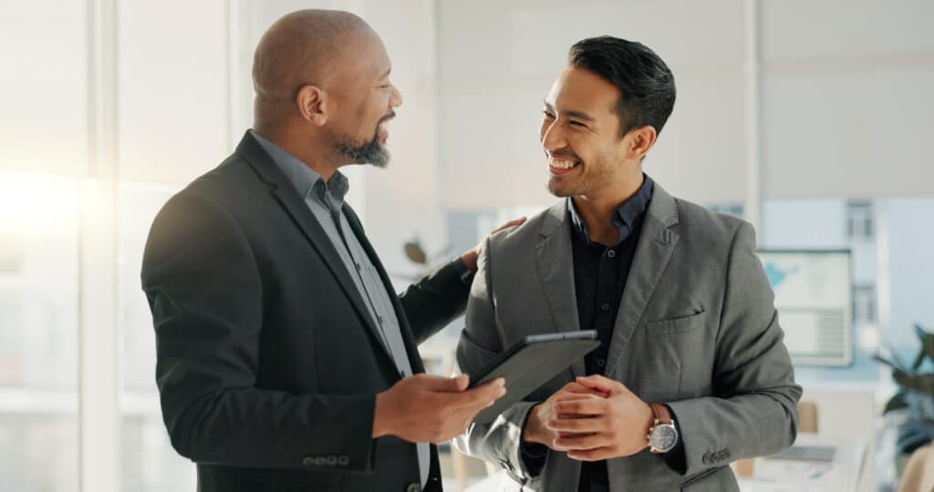 Two board members use a tablet to access an AI meeting minutes generator through their board portal.