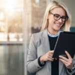 Woman uses her tablet to explore board management software for financial services.