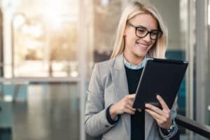 Woman uses her tablet to explore board management software for financial services.