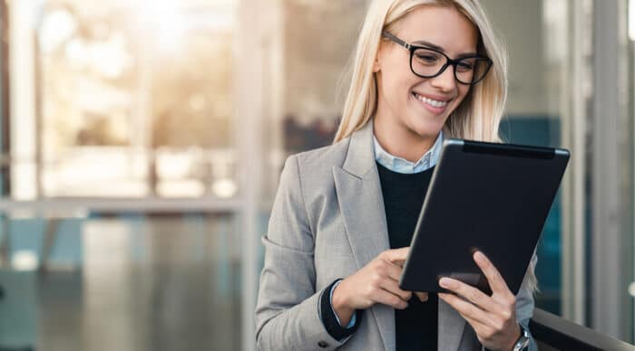 Woman uses her tablet to explore board management software for financial services.