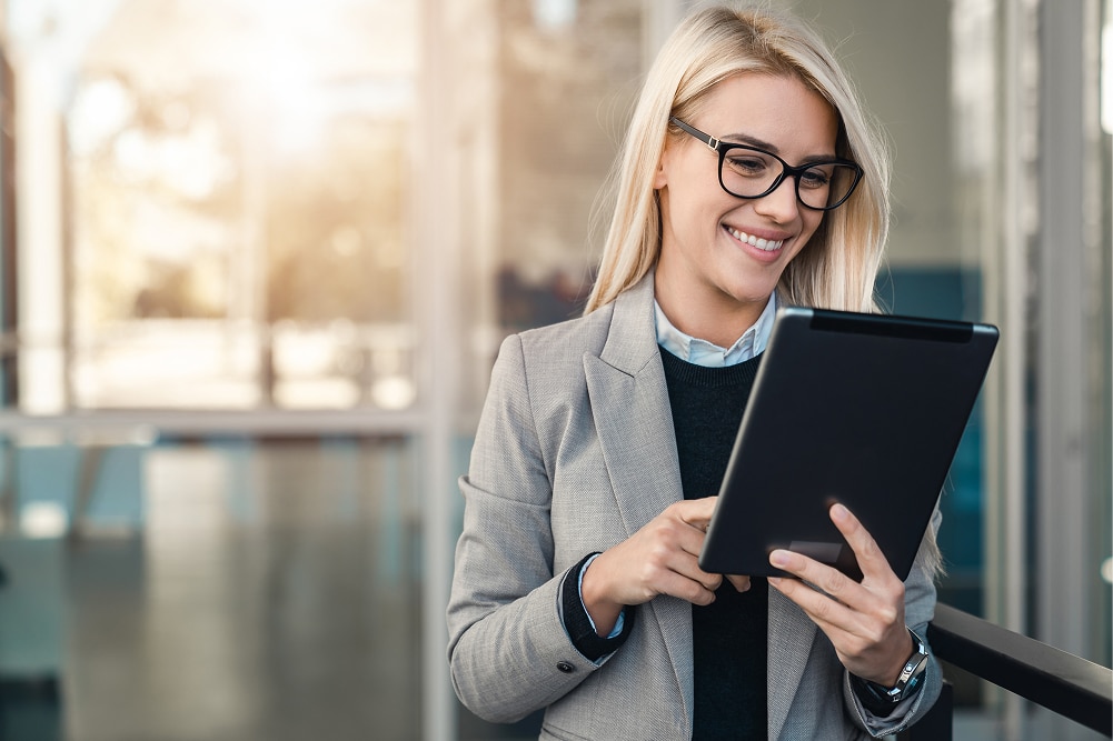 Woman uses her tablet to explore board management software for financial services.