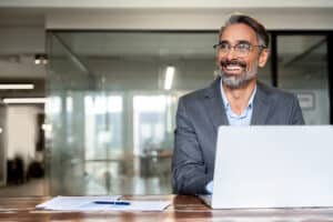 Board director sits at a laptop reviewing how to build a board development plan.