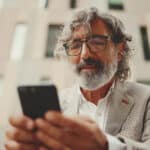 Man uses is phone to access school board software.