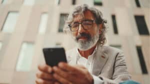 Man uses is phone to access school board software.