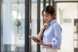 Woman uses her tablet to review a nonprofit board meeting agenda.